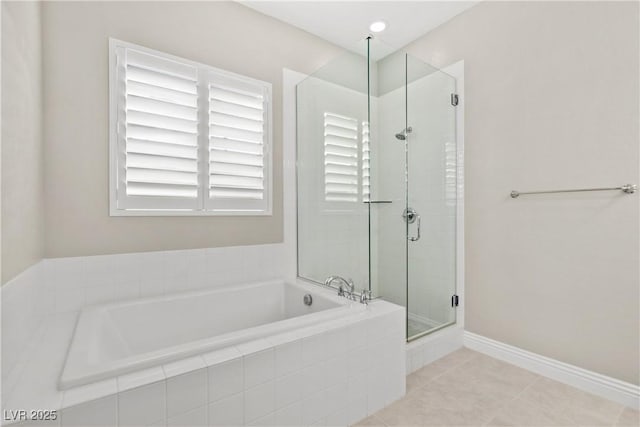 full bathroom featuring tile patterned flooring, a shower stall, baseboards, and a garden tub