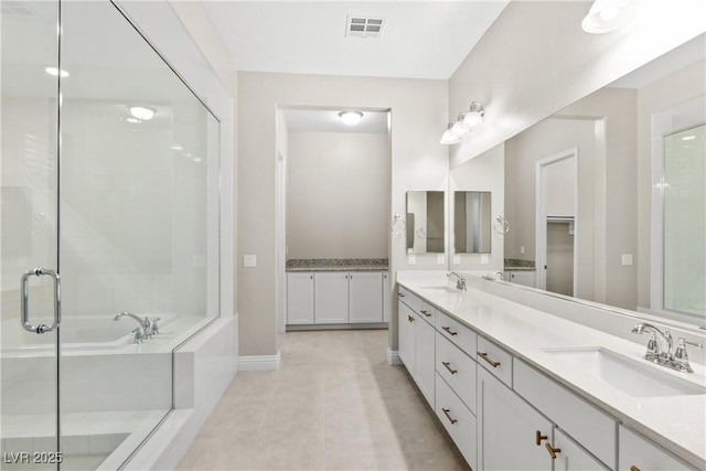 bathroom featuring double vanity, visible vents, a shower stall, and a sink