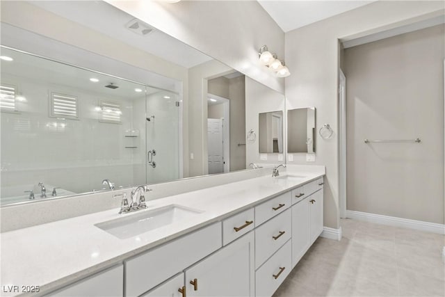 bathroom with a shower stall, double vanity, baseboards, and a sink