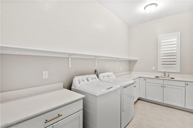 clothes washing area featuring a sink, light tile patterned floors, cabinet space, and washer and clothes dryer