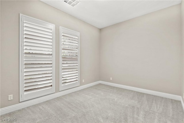 spare room with baseboards, visible vents, and carpet floors