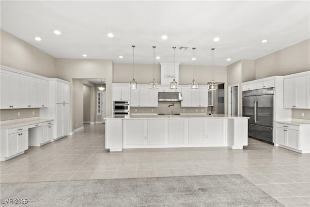 kitchen featuring under cabinet range hood, light tile patterned floors, stainless steel appliances, and light countertops