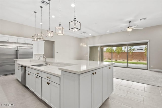 kitchen with a large island, visible vents, appliances with stainless steel finishes, and a sink