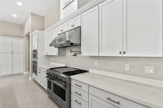 kitchen featuring under cabinet range hood, light countertops, range with two ovens, recessed lighting, and white cabinets