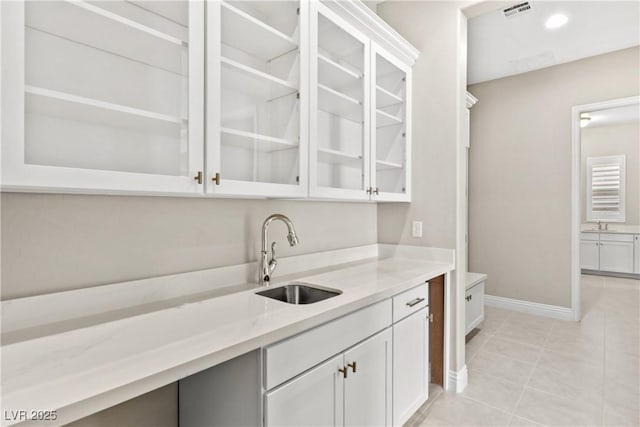 bar with visible vents, a sink, recessed lighting, light tile patterned floors, and baseboards