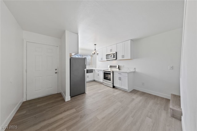 kitchen with white cabinetry, light wood-style flooring, and appliances with stainless steel finishes