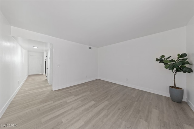 unfurnished room with visible vents, light wood-style floors, and baseboards