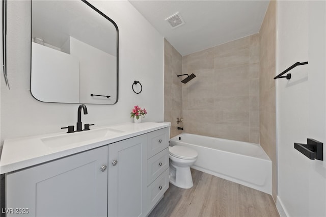 full bathroom with visible vents, toilet, bathtub / shower combination, wood finished floors, and vanity