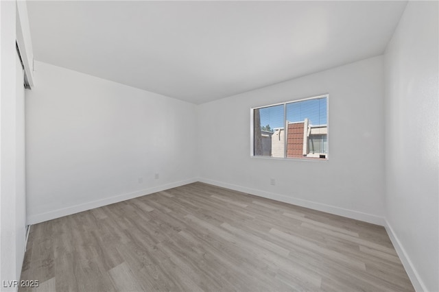 empty room featuring wood finished floors and baseboards