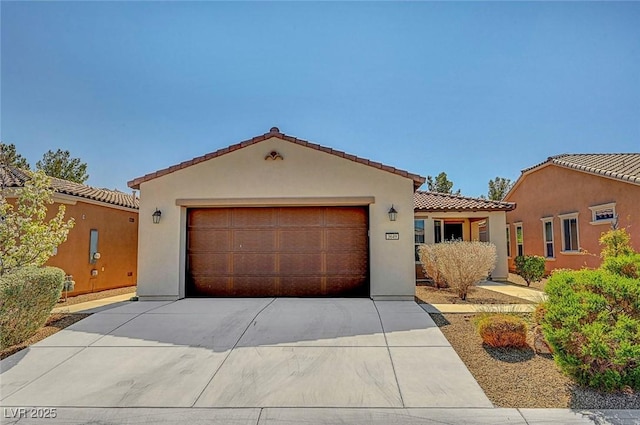 mediterranean / spanish house featuring stucco siding, concrete driveway, and a tiled roof