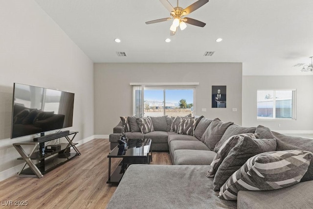 living room with visible vents, recessed lighting, light wood-type flooring, and baseboards