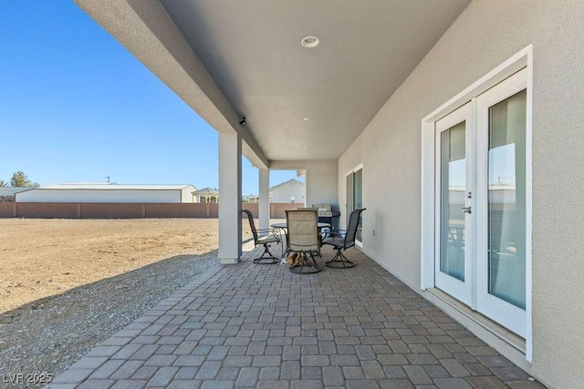 view of patio with outdoor dining area and fence