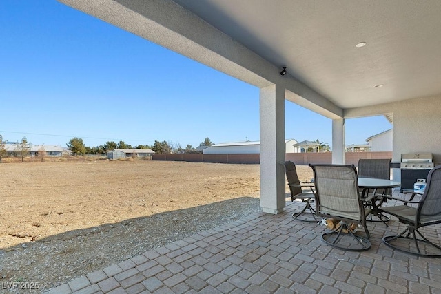 view of patio with outdoor dining space, a fenced backyard, and grilling area