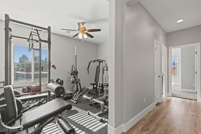 workout area with ceiling fan, baseboards, and wood finished floors