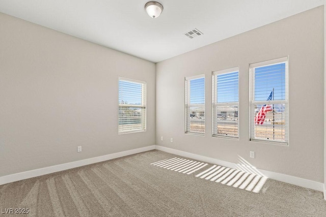 carpeted empty room featuring visible vents and baseboards