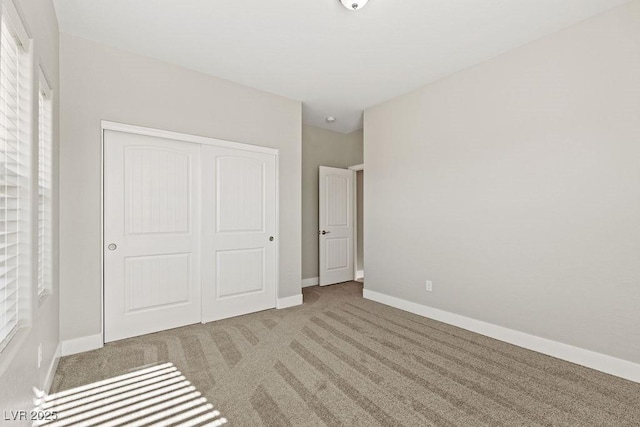 unfurnished bedroom featuring a closet, baseboards, and carpet floors