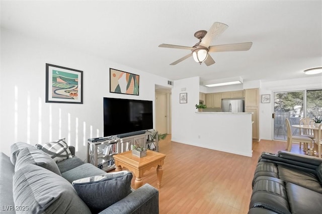 living area with visible vents, a ceiling fan, and light wood finished floors