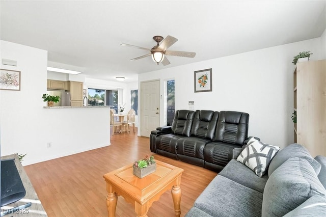 living area with a ceiling fan and light wood finished floors