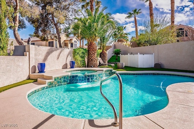 view of swimming pool featuring a pool with connected hot tub and a fenced backyard