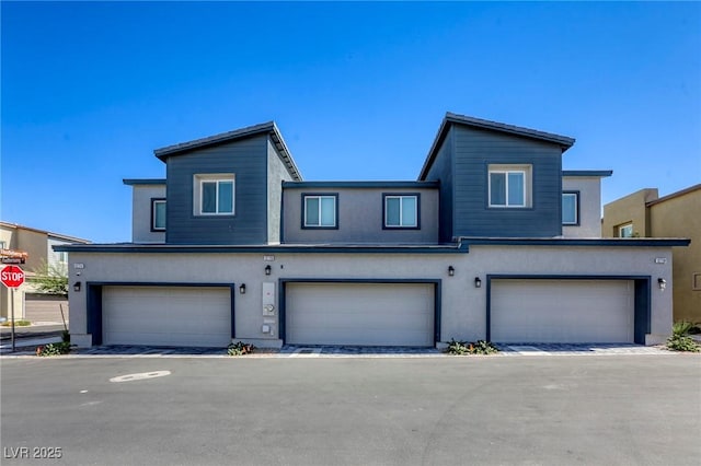 multi unit property featuring a garage and stucco siding