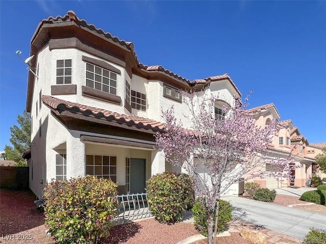 mediterranean / spanish-style home with concrete driveway, a garage, and stucco siding