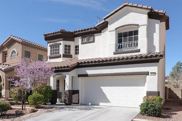 mediterranean / spanish-style home featuring a garage, driveway, and stucco siding