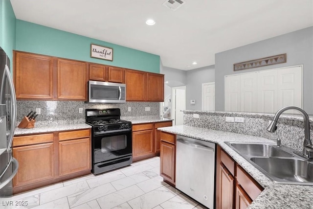 kitchen with backsplash, brown cabinets, marble finish floor, stainless steel appliances, and a sink