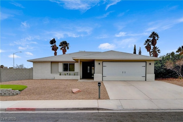 ranch-style home with concrete driveway, an attached garage, and fence