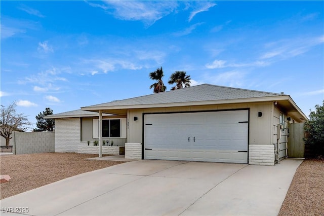 ranch-style home with a garage, driveway, and fence