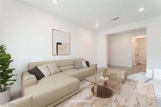 tiled living area featuring visible vents, recessed lighting, and baseboards