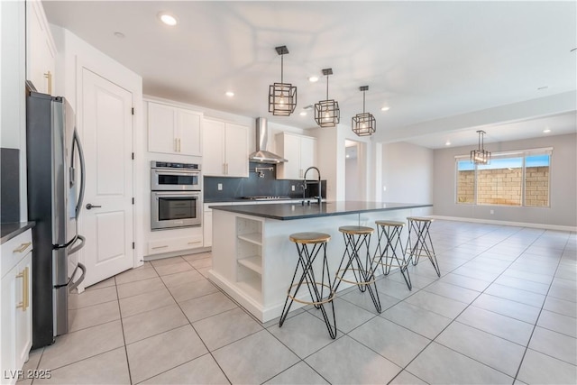 kitchen featuring light tile patterned flooring, a sink, stainless steel appliances, dark countertops, and wall chimney exhaust hood