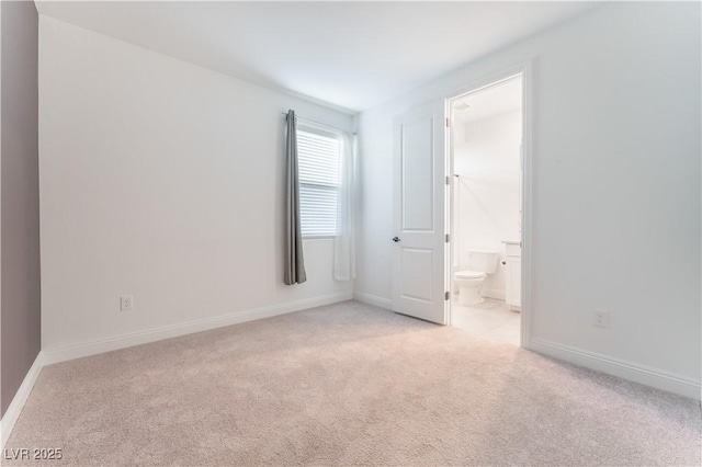 unfurnished room with baseboards and light carpet