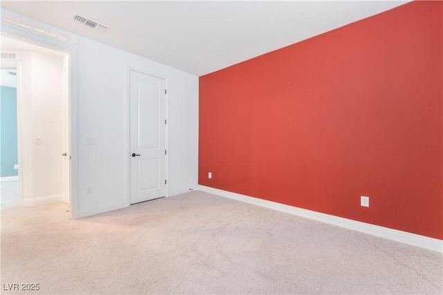 carpeted spare room with visible vents and baseboards