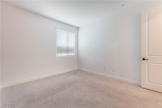 empty room with baseboards and light carpet