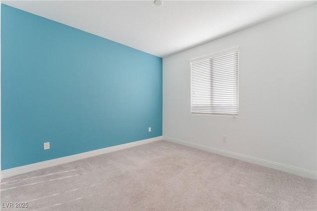 carpeted spare room featuring baseboards