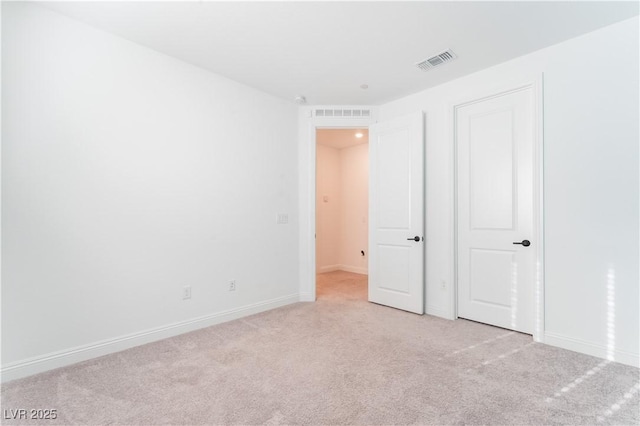 unfurnished bedroom with light colored carpet, visible vents, and baseboards