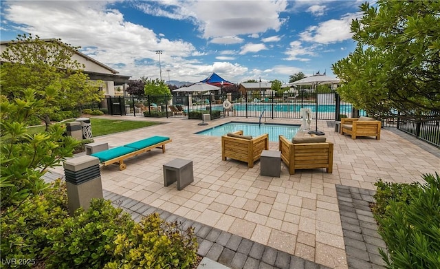 pool featuring a patio area, outdoor lounge area, and fence