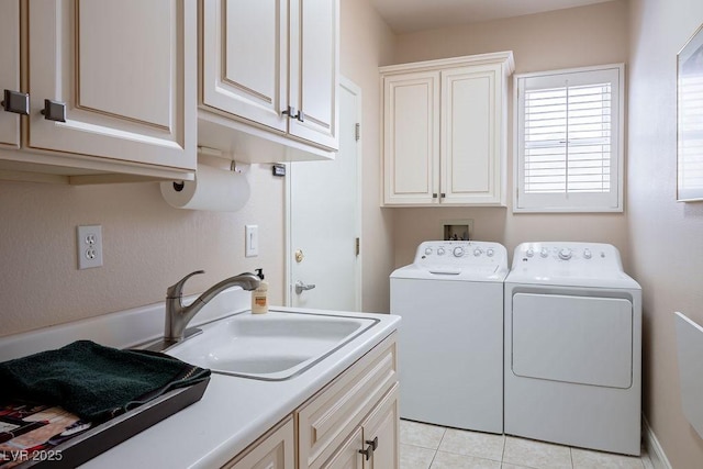 laundry area featuring a sink, cabinet space, separate washer and dryer, and light tile patterned floors
