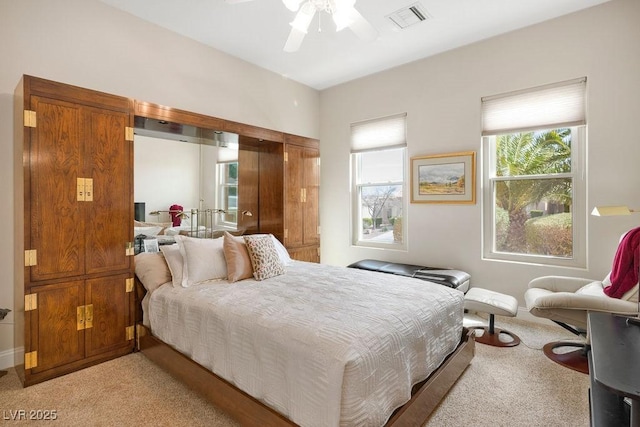 bedroom with a ceiling fan, light colored carpet, and visible vents