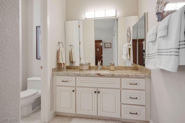 bathroom featuring tile patterned floors, toilet, and vanity
