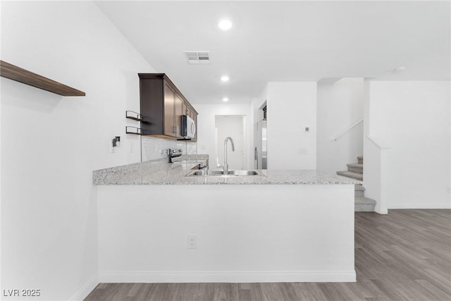 12367 Indigo Montage Rd Unit 3, Las Vegas, NV 89183 - kitchen with a sink, range, light wood-type flooring, dark brown cabinetry, and open shelves