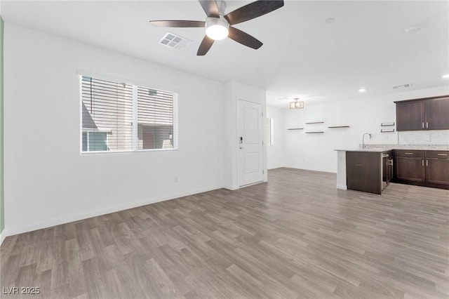 12367 Indigo Montage Rd Unit 3, Las Vegas, NV 89183 - unfurnished living room with light wood-style flooring, ceiling fan, a sink, and baseboards