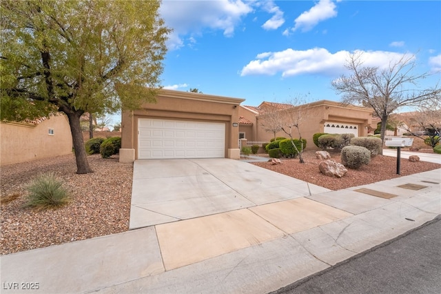 pueblo-style home featuring stucco siding, an attached garage, and concrete driveway