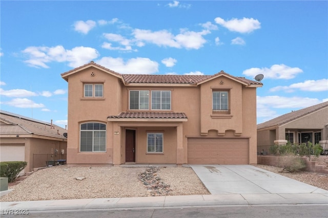 mediterranean / spanish home with stucco siding, concrete driveway, an attached garage, and a tiled roof