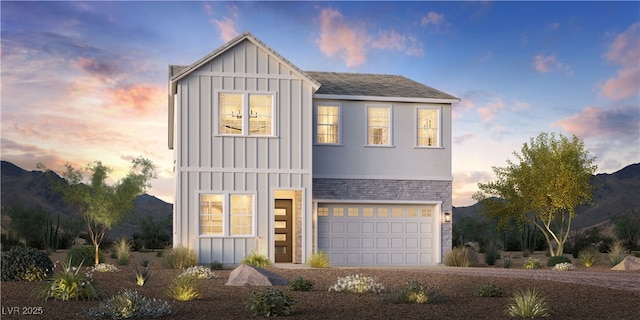 view of front of home featuring stone siding, an attached garage, board and batten siding, and driveway