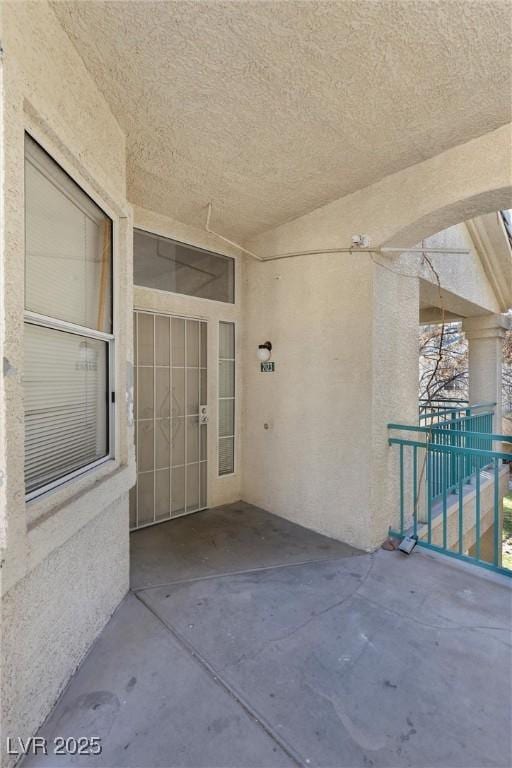 property entrance with stucco siding and a patio area