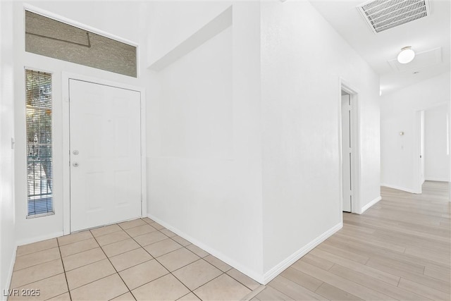 foyer entrance featuring light wood-style flooring, baseboards, and visible vents