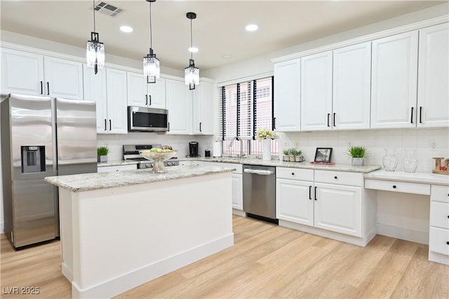 kitchen featuring visible vents, light wood-style flooring, white cabinets, and stainless steel appliances