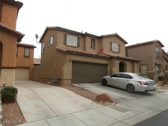 mediterranean / spanish home with a garage, driveway, and stucco siding