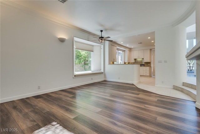 unfurnished living room featuring ornamental molding, ceiling fan, baseboards, and wood finished floors